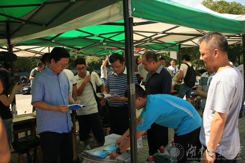 校领导仔细查看发给新生的学生手册和宣传资料 舒杨摄